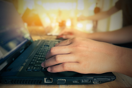 close up hand of business man using laptop with teamwork together and morning light.vintage filter...