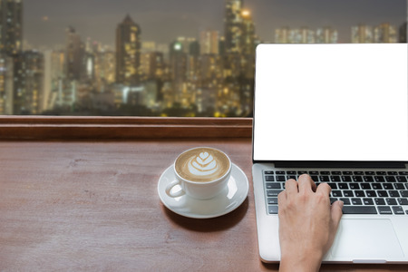 close up hand young business man using laptop and mouse on wooden desk in office.の写真素材