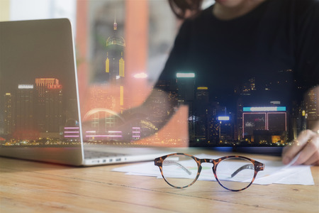 Double exposure of Building constructure and Image of Business women working with laptop computer in home office. selective focusの写真素材