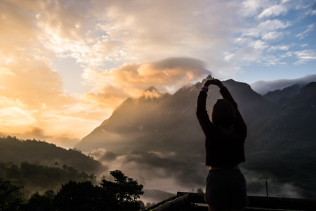 Young Woman relaxing outdoor travel lifestyle mountains on background and sunrise in the morning. selective focus.の写真素材