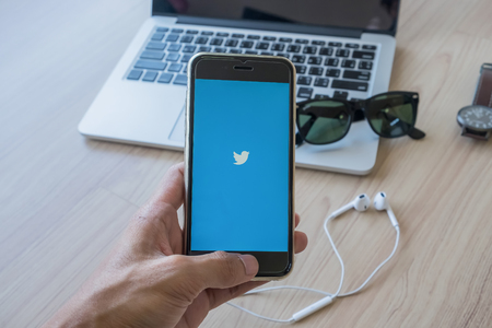 CHIANG MAI, THAILAND - FEB 03, 2016: Person holding a brand new Apple iPhone  with Twitter logo on the screen. Twitter is a social media online service for microblogging and networking communication.のeditorial素材