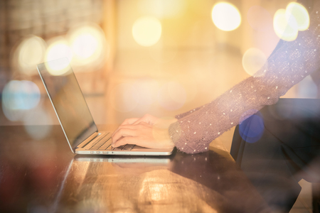 Beautyful business woman using pen and laptop with bokeh at workplace.の写真素材