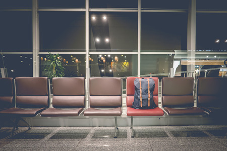 Backpack on chair in the departure hall at airport at midnight. Travel and transportation concepts.