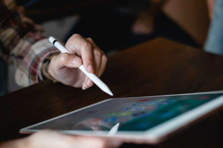 CHIANG MAI, THAILAND - FEB 26, 2020 : Hand of woman using Ipad and pencil with icons of social media on screen, smartphone life style, smartphone era, smartphone in everyday lifeのeditorial素材
