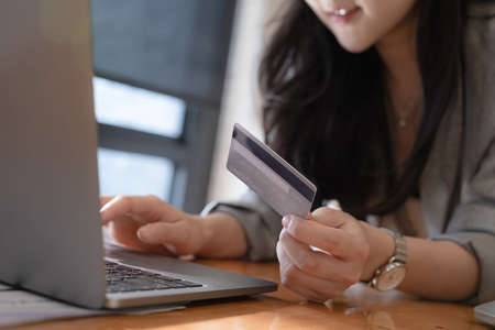 Online Shopping. Asian woman typing credit card information by laptop for shopping online.の写真素材