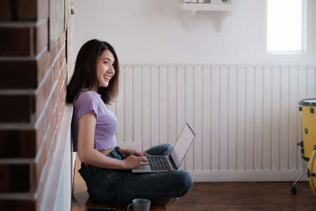 Portrait of beautiful woman and smiling using video call on laptop computer with her parents. Quarantine and work from home concept.の写真素材
