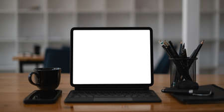 White blank screen tablet on modern working desk.の写真素材