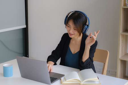 Portrait of businesswoman discussing to her partners about new product while video conference in...