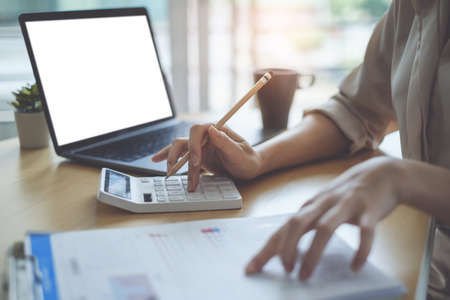 Asian Business woman accountant or banker use calculator and audit finance planning sales to meet targets.の写真素材