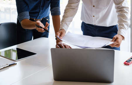 Two Architect man working with laptop and blueprints for architectural plan, engineer sketching a...