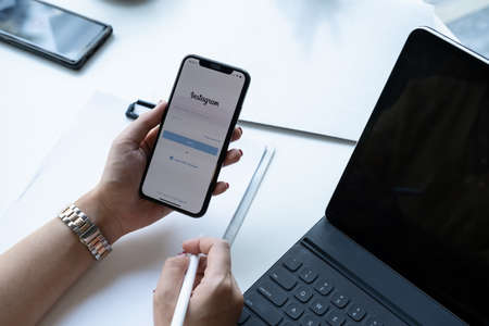 CHIANG MAI, THAILAND - NOV 07, 2020 : Woman hand holding iphone with login screen of instagram...
