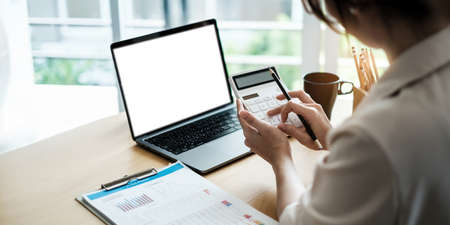 Close up of woman calculating financial or taxes or household on calculator, female calculate while...