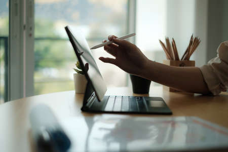 Creative designer designer carrying pencil and sketches her idea on laptop. Business day work...