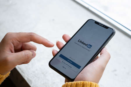 CHIANG MAI, THAILAND APR 27 2021 : A women holds Apple iPhone with LinkedIn application on the screen.LinkedIn is a photo-sharing app for smartphones.のeditorial素材