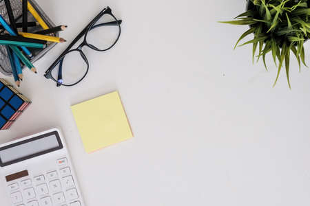 Modern white wooden desk table calculator and business tools office. top view.