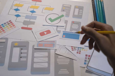 Designers drawing mobile ux app development concept. Man hold pencil with mockup ui.の写真素材