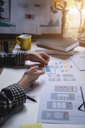 Rear view developer ux and ui designer about mobile phone app and choosing some interface to mockup...