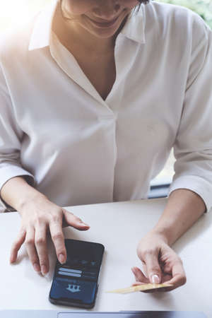Female using mobile banking application for paying house,tax and billの写真素材