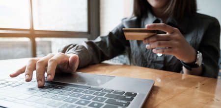 Woman enjoy with online shopping application and looking at credit card for fill number to payment.