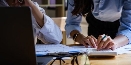 For the investigation of a corruption account, a group of businesswomen and accountants search data documents on a laptop. definition of anti-bribery.の写真素材
