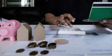 American african with a savings account calculates the amount of money he can save this year. account or saving money or insurance conceptの写真素材