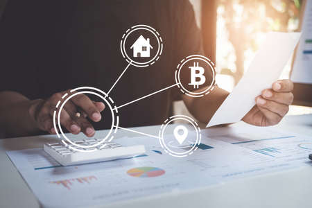 American african man is managing, calculating the debt and holding cost bill with virtual icon on screen.の写真素材