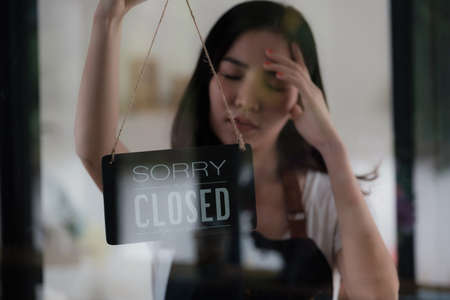Store Owner Turning Closed. Stressed owner forced to close the coffee shop permanently due to restrictionsの写真素材