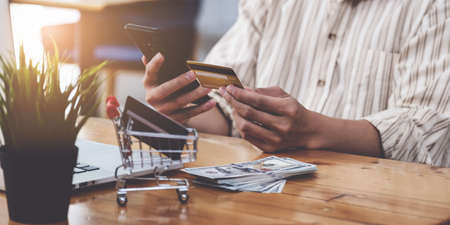 A Man holding credit card and typing in credit card number smartphone for online shopping and payment makes a purchase on the Internet.の写真素材