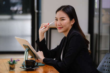 At her coffee shop, the business owner or barista is taking orders from online customers by application on tablet.の写真素材