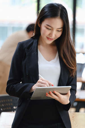 At her coffee shop, the business owner or barista is taking orders from online customers by...