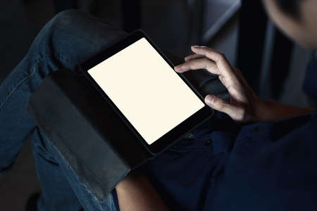 Mockup image of a black tablet with white blank screen on wooden desk