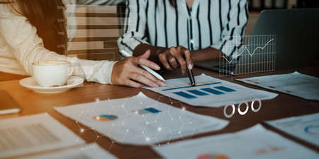 Business people gather in a corporate location to discuss research using paperwork. Concept of a group of businesses cooperatingの写真素材