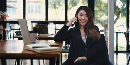 Portrait of a beautiful Secretary conversing with a scheduled customer by cell phone