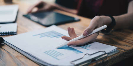 Business woman do financial accounting stock market graphs analysis on paperwork in officeの写真素材