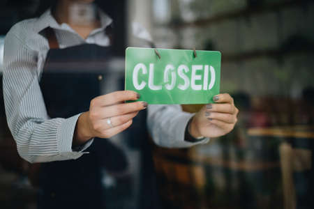Store Owner Turning Closed. Stressed owner forced to close the coffee shop permanently due to restrictions on the COVID-19.の写真素材