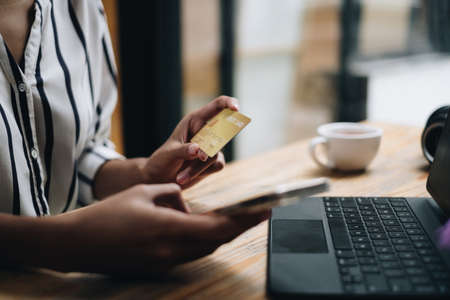Woman enjoy with online shopping application on mobile phone and typing credit card for fill number to payment.の写真素材