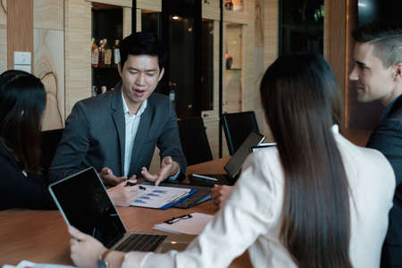 Multiracial business people gather to discuss the companys market plan for the coming year. Teamwork Togetherness Unity Conceptの写真素材