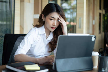 Frustrated stressed business owner or accountant sitting in an office because covid-19 has disappoint. Close business cafe shop concept.の写真素材