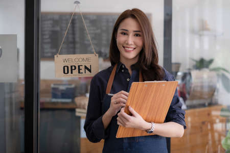 Portrait of a beautiful barista with tablet at her cafe. small business owner concept.の写真素材