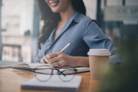 Portrait of cheerful asian woman with casual life on desk in home office. Concept of young business people working at home.の写真素材