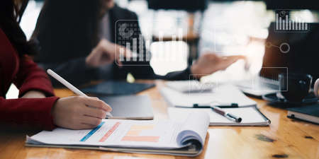 Business team is brainstorming with charts and analyzing or studying for investments. Account,...