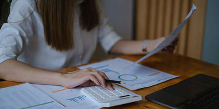 A businesswoman examines a financial chart in order to make arrangements. Investment concept for a business fund.の写真素材