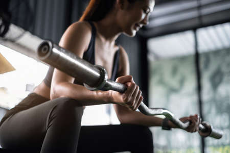 Attractive fit woman workout with barbell in gym fitness. Portrait sport and Healthy concept.の写真素材
