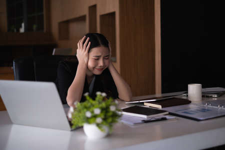 Frustrated stressed business financial or accountant sitting in an office because covid-19 has disappoint.の写真素材