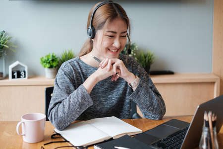 E-learning ,online ,education and internet social distancing protect from COVID-19 viruses concept. Asian woman student video conference e-learning with teacher on laptop computer at home.の写真素材