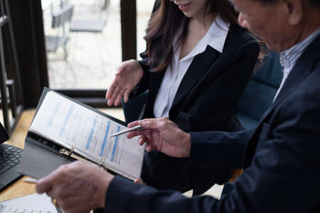 Insurance agent offers and explain health insurance life plan for elderly. Adult man choosing plan of life and saving Insurance.の写真素材