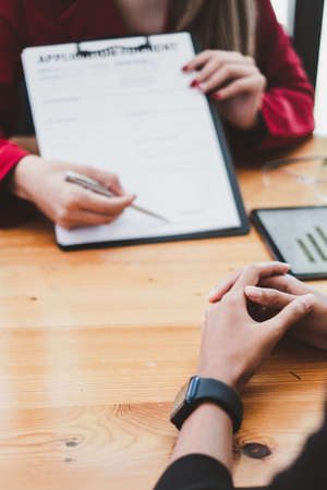 Close up of Business woman pointing and signing agreement for buying house. Bank manager and real...