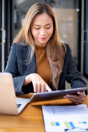 Business Finance and Accounting Concept. Business woman using security application on tablet to protect her money.の写真素材