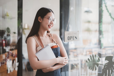 Portrait of Woman barista cafe owner smile while cafe open. SME entrepreneur seller business...