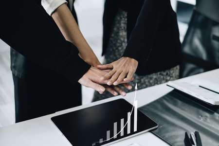 Group of business people putting their hands working together on wooden background in office. group support teamwork agreement concept.の写真素材